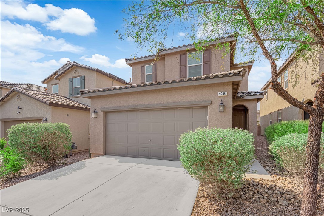 9205 Keystone Ridge Avenue Las Vegas, NV 89148 - Photo 3 of 40 Mediterranean / spanish house featuring a tiled roof, concrete driveway, and stucco siding
