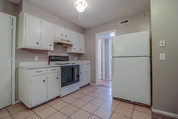 a kitchen with a refrigerator sink stove and cabinets