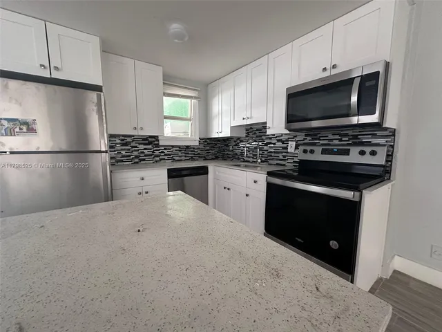 a kitchen with stainless steel appliances a stove microwave and refrigerator