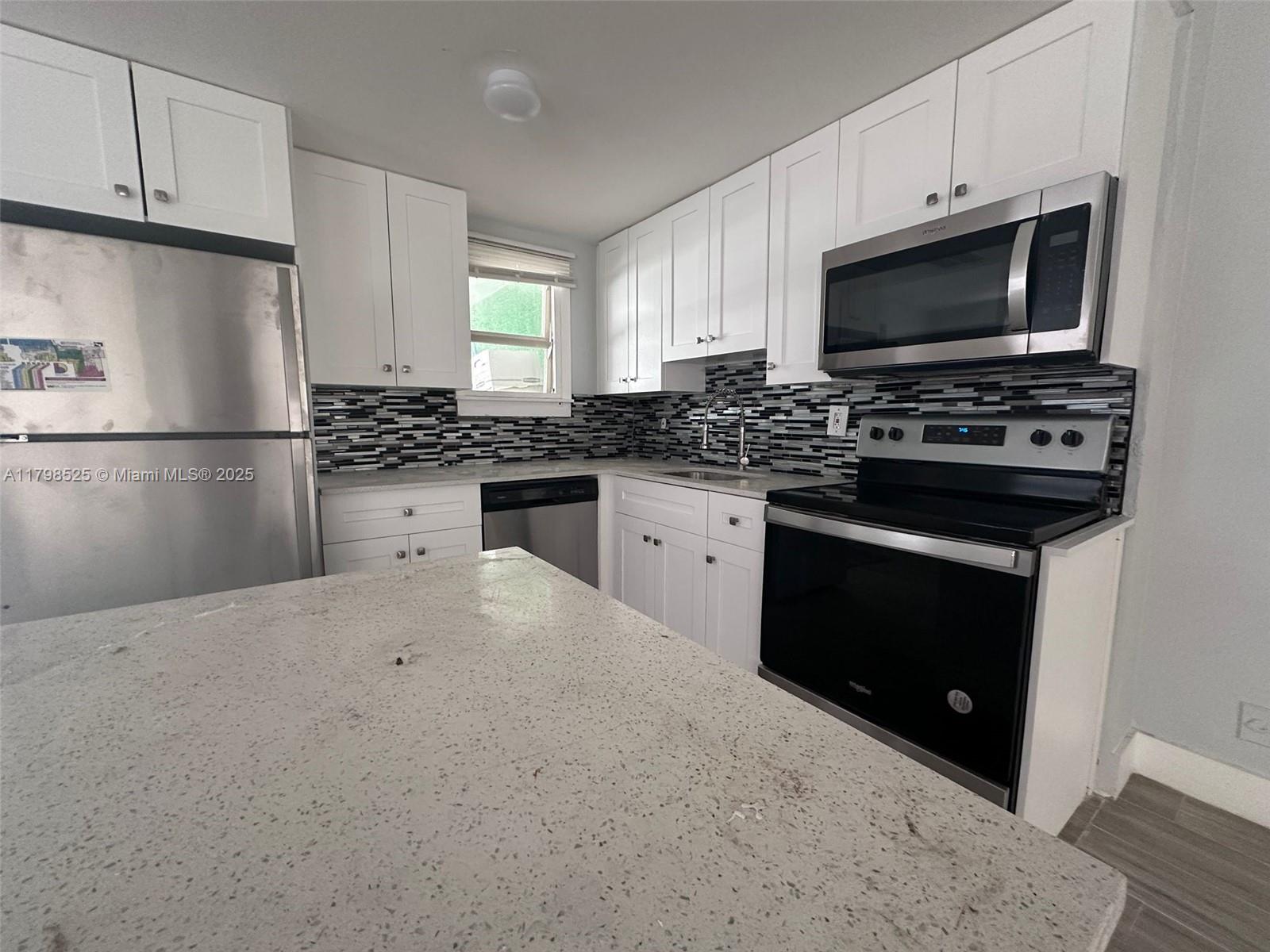 a kitchen with stainless steel appliances a stove microwave and refrigerator