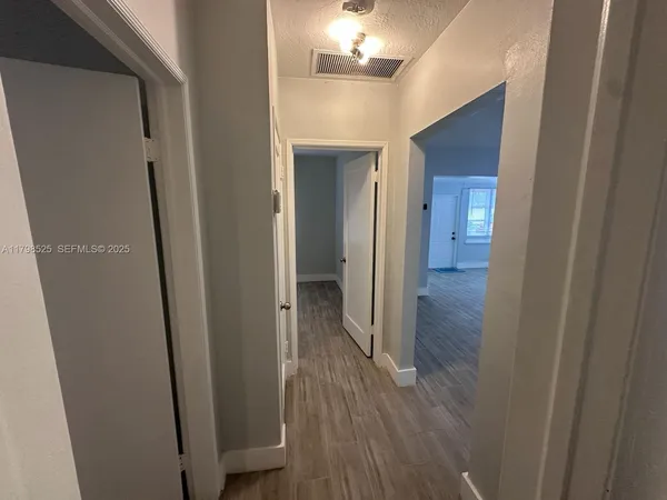 a view of a hallway with wooden floor