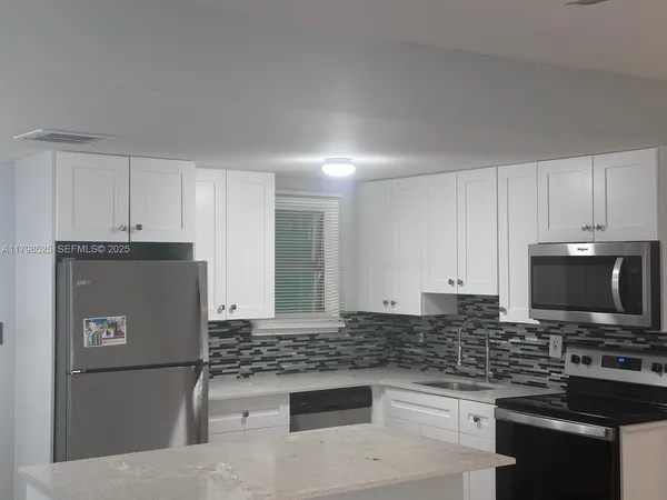 a kitchen with granite countertop a stove and a sink