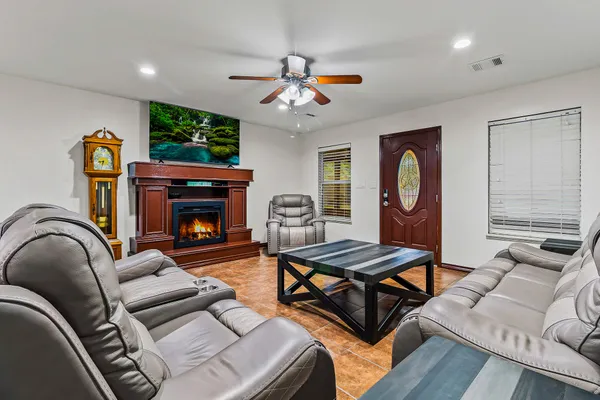 a living room with furniture a fireplace and a flat screen tv
