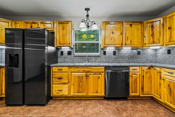 a kitchen with stainless steel appliances kitchen island granite countertop a large counter top and a refrigerator