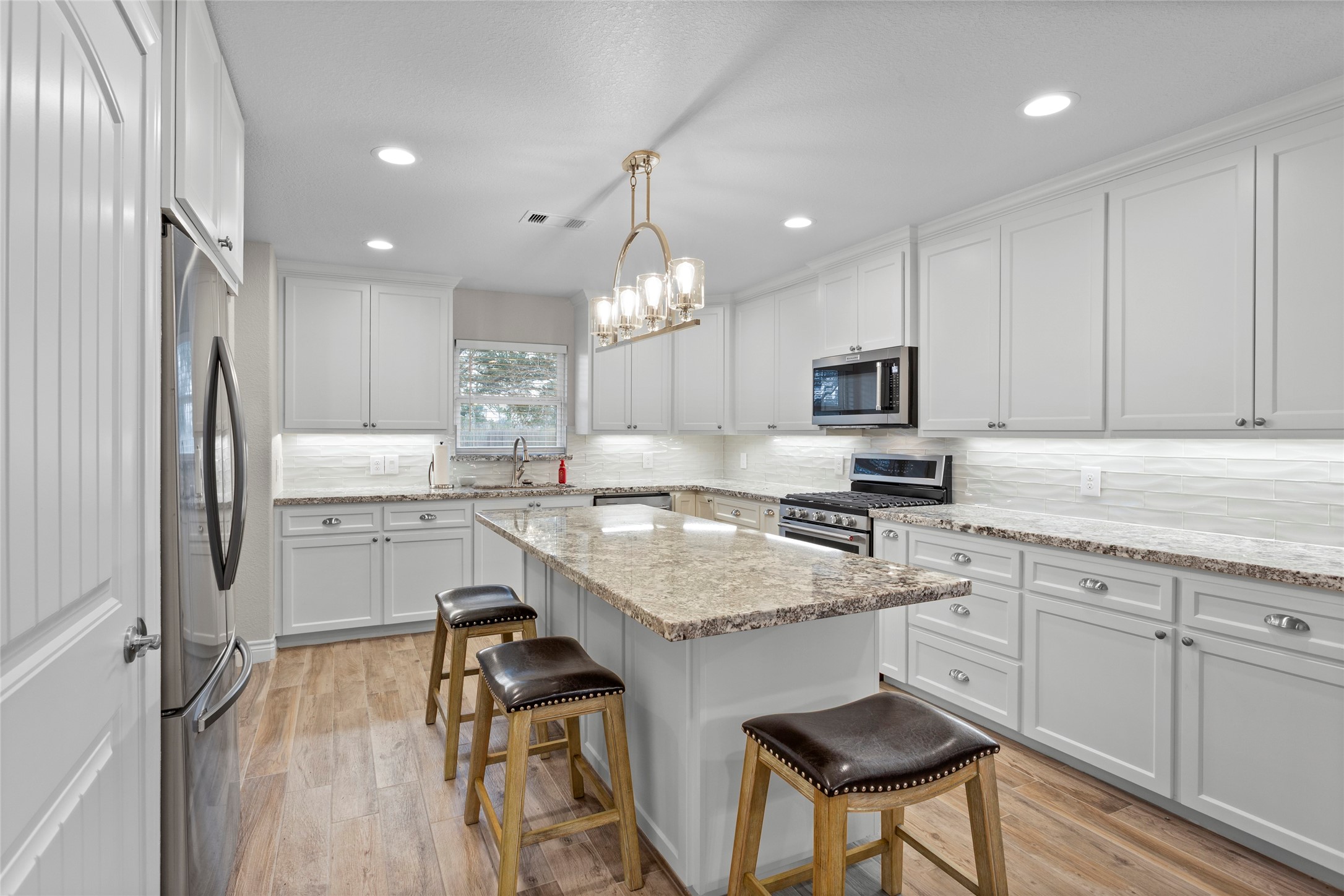13800 West 6th Street Santa Fe, TX 77517 - Photo 16 of 35 a kitchen with kitchen island granite countertop a sink cabinets and stainless steel appliances