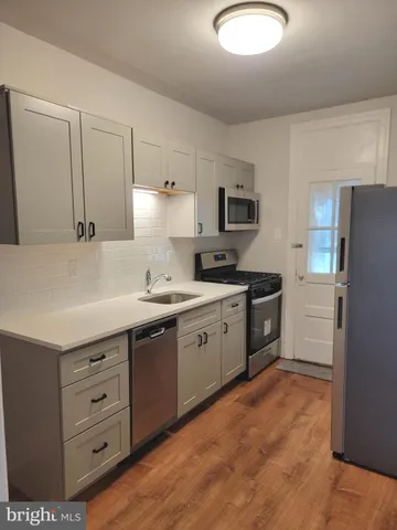 a kitchen with cabinets appliances and a sink