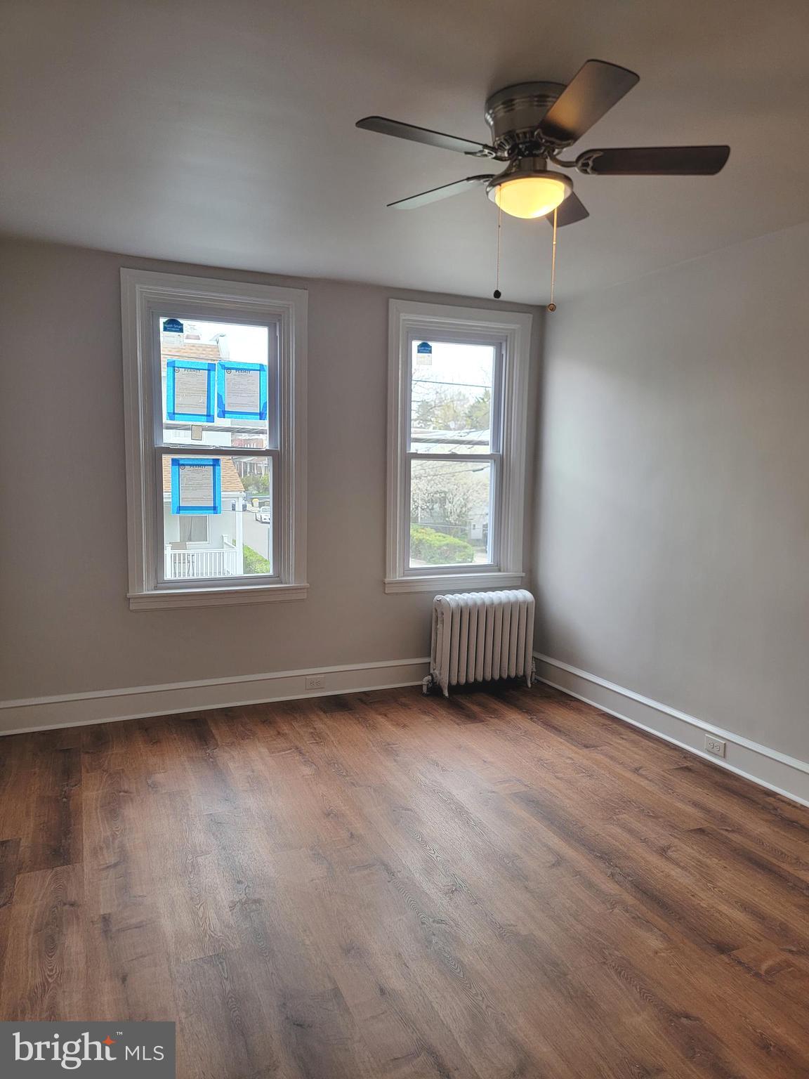 56 East Spring Avenue, Unit 2 Ardmore, PA 19003 - Photo 10 of 12 a view of an empty room with a window and wooden floor
