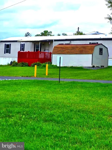 a view of a big house with a big yard and large trees