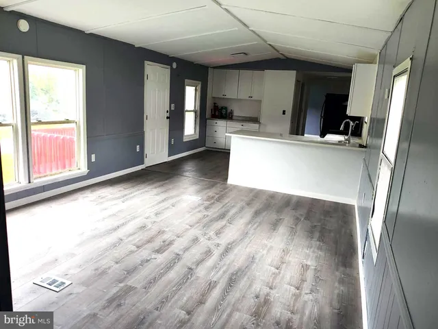 a view of a kitchen with wooden floor and a window