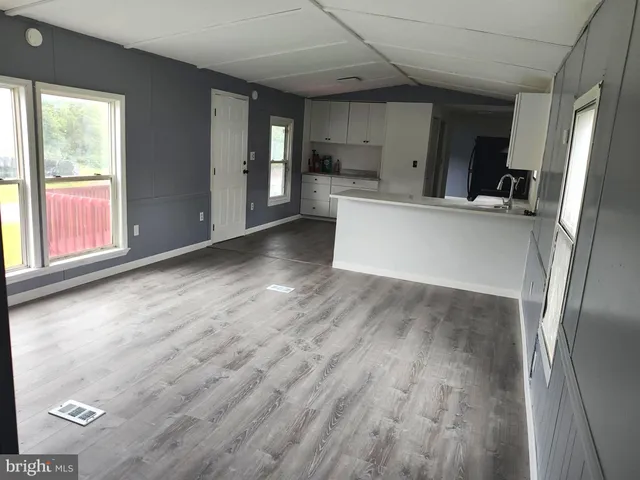 a view of a kitchen with wooden floor and electronic appliances