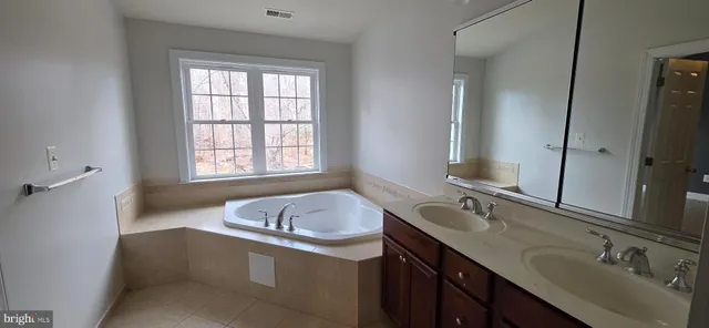 a bathroom with a granite countertop sink and a bathtub