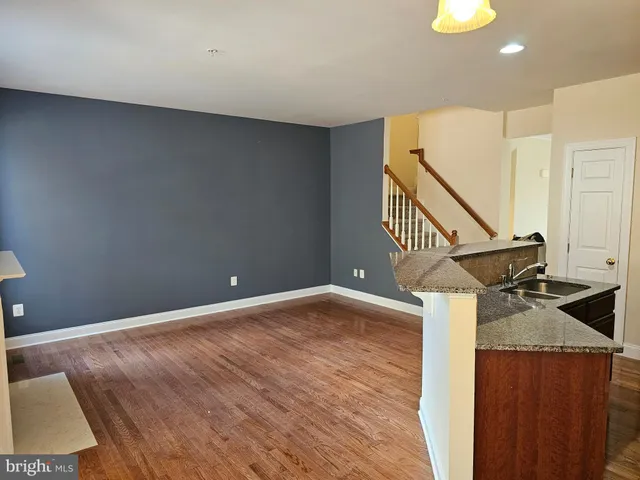 a view of a livingroom with wooden floor and stairs