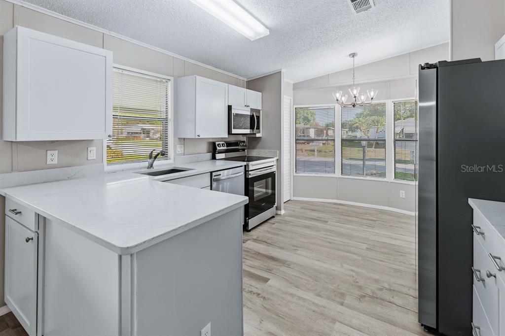 2828 Southwest Toronado Trail Stuart, FL 34997 - Photo 12 of 46 a kitchen with wooden cabinets and a refrigerator