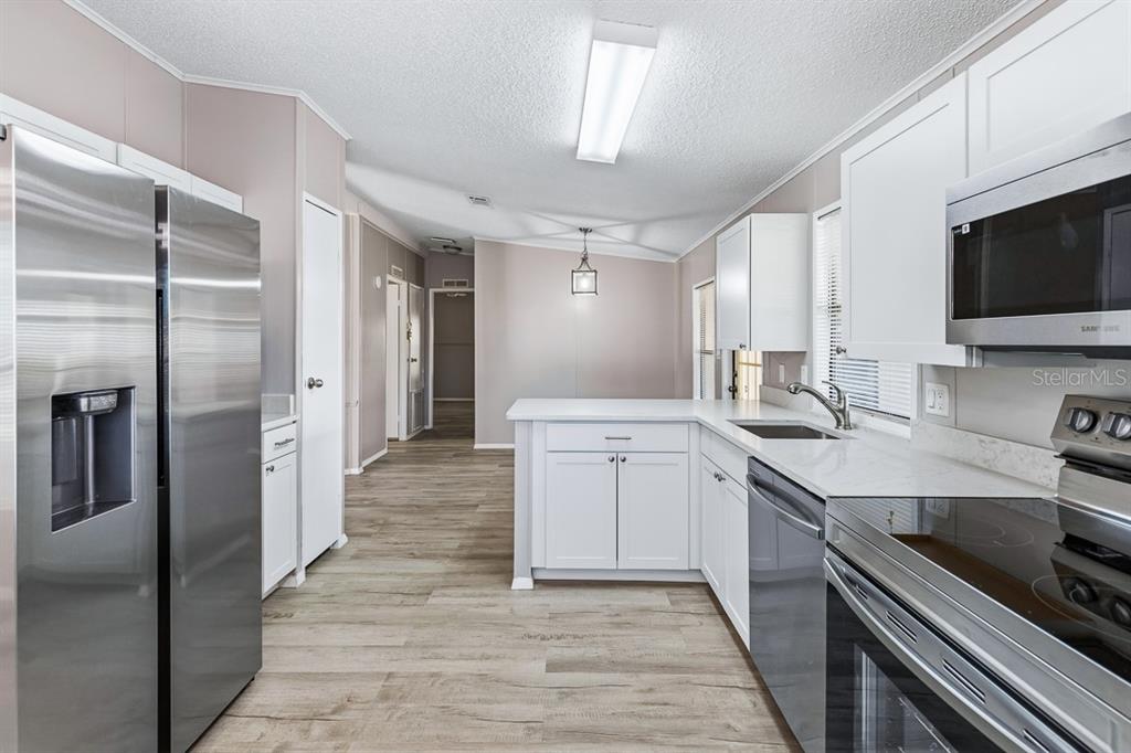 2828 Southwest Toronado Trail Stuart, FL 34997 - Photo 13 of 46 a kitchen with a sink stainless steel appliances and cabinets