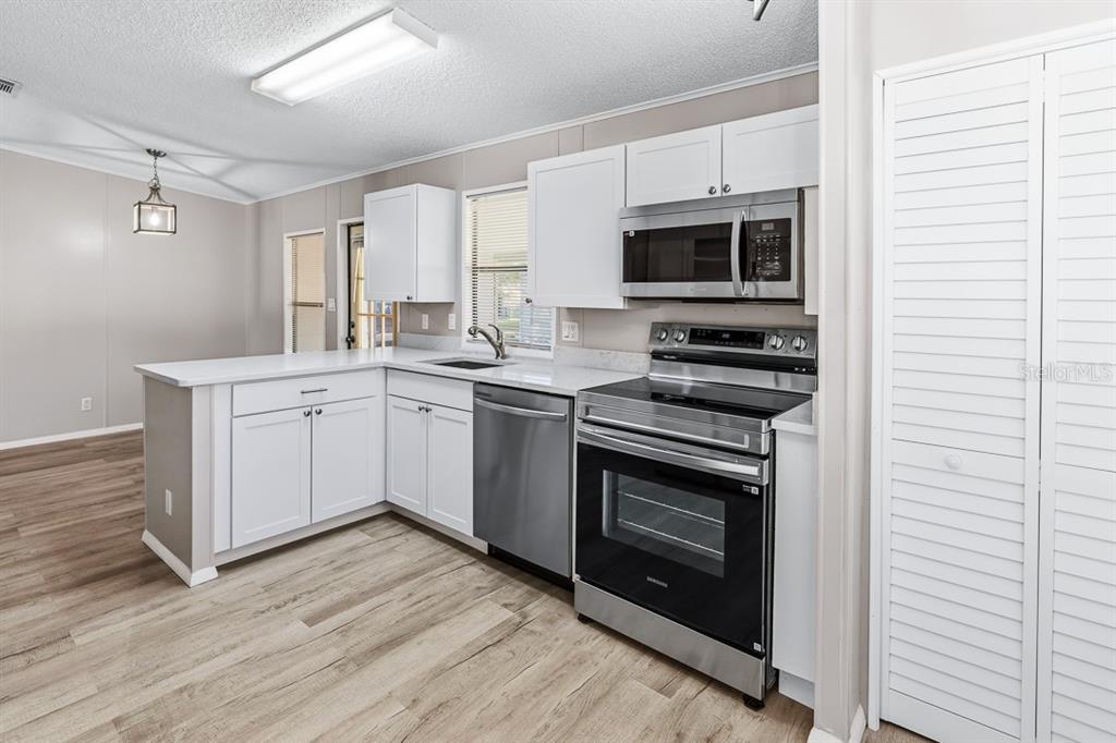 2828 Southwest Toronado Trail Stuart, FL 34997 - Photo 14 of 46 a kitchen with stainless steel appliances granite countertop a stove a sink and a microwave