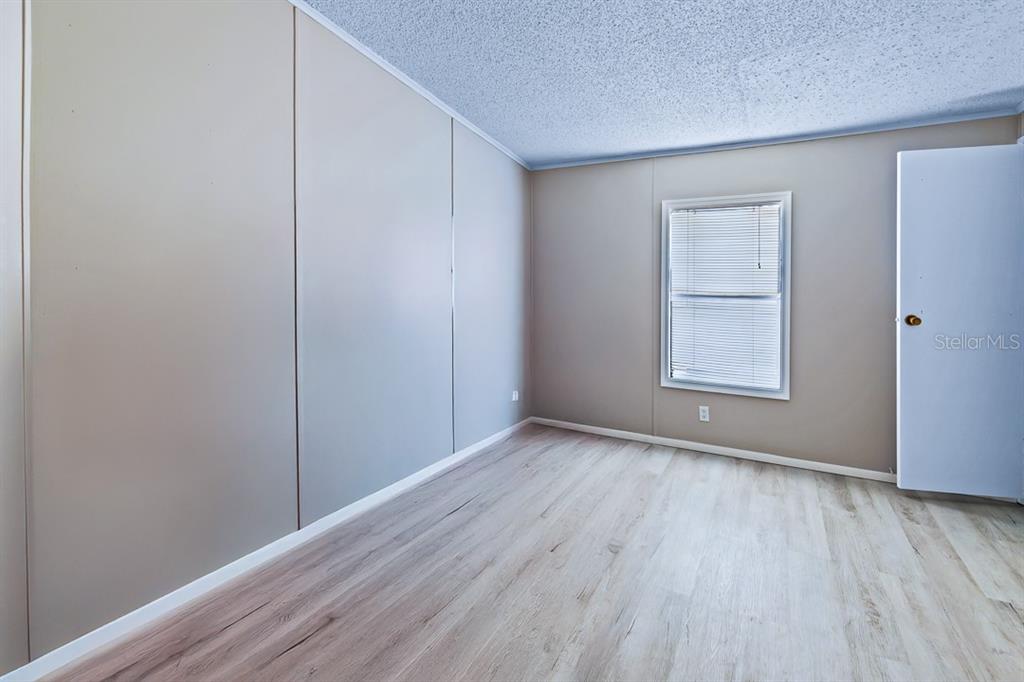 2828 Southwest Toronado Trail Stuart, FL 34997 - Photo 20 of 46 a view of an empty room with wooden floor and a window