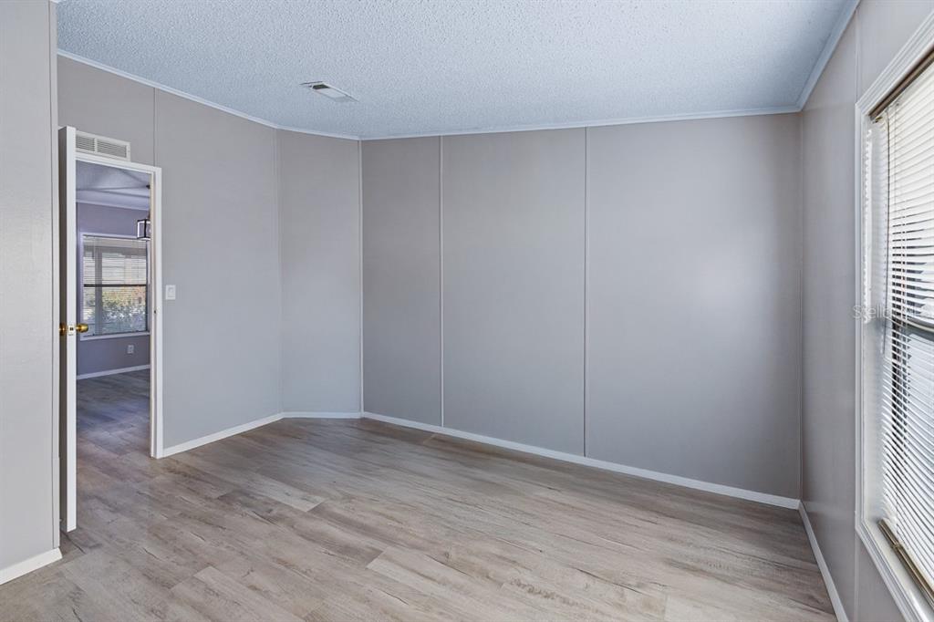 2828 Southwest Toronado Trail Stuart, FL 34997 - Photo 21 of 46 an empty room with wooden floor and windows