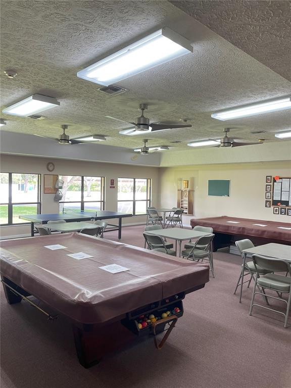 2828 Southwest Toronado Trail Stuart, FL 34997 - Photo 45 of 46 a room with stainless steel appliances dining table a chandelier and a large window