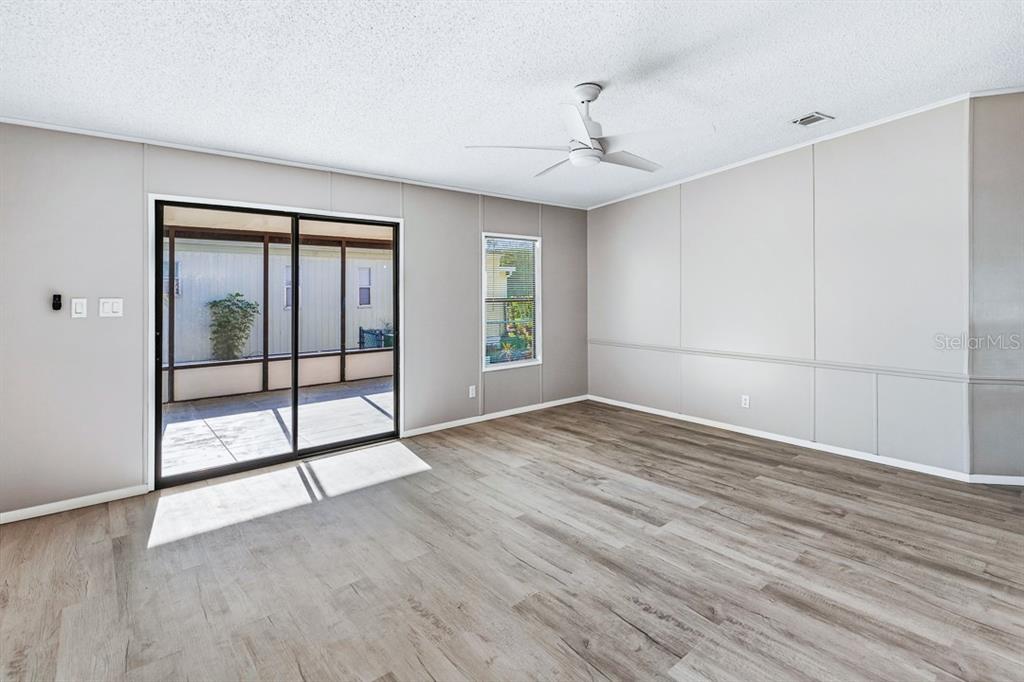 2828 Southwest Toronado Trail Stuart, FL 34997 - Photo 6 of 46 a view of empty room with wooden floor and fan