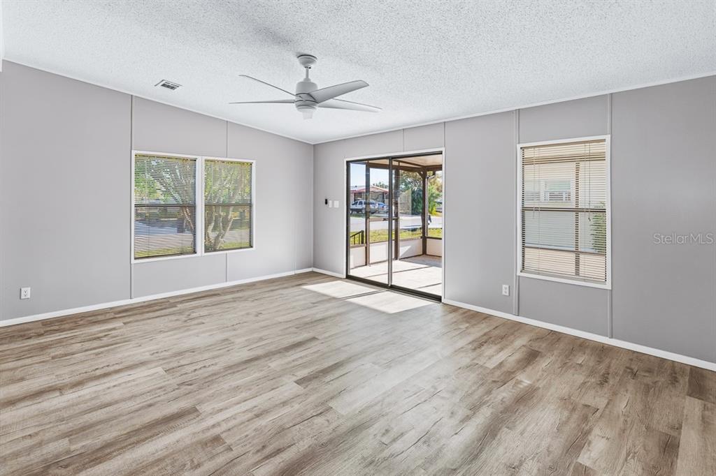 2828 Southwest Toronado Trail Stuart, FL 34997 - Photo 7 of 46 a view of an empty room with a window and wooden floor
