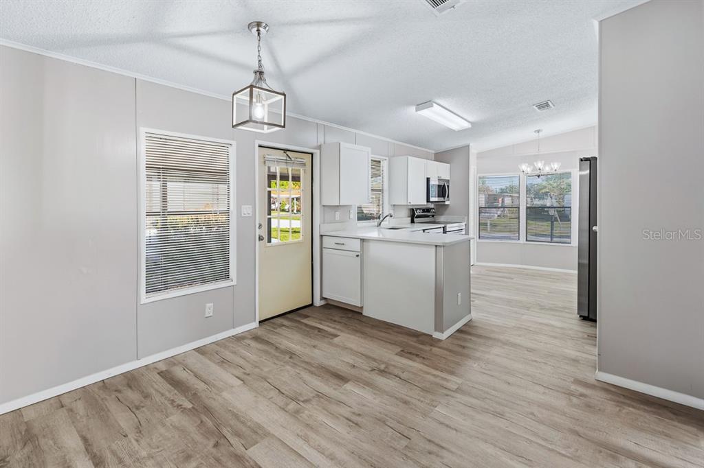 2828 Southwest Toronado Trail Stuart, FL 34997 - Photo 9 of 46 a kitchen with kitchen island a sink a stove a refrigerator cabinets and a dining table