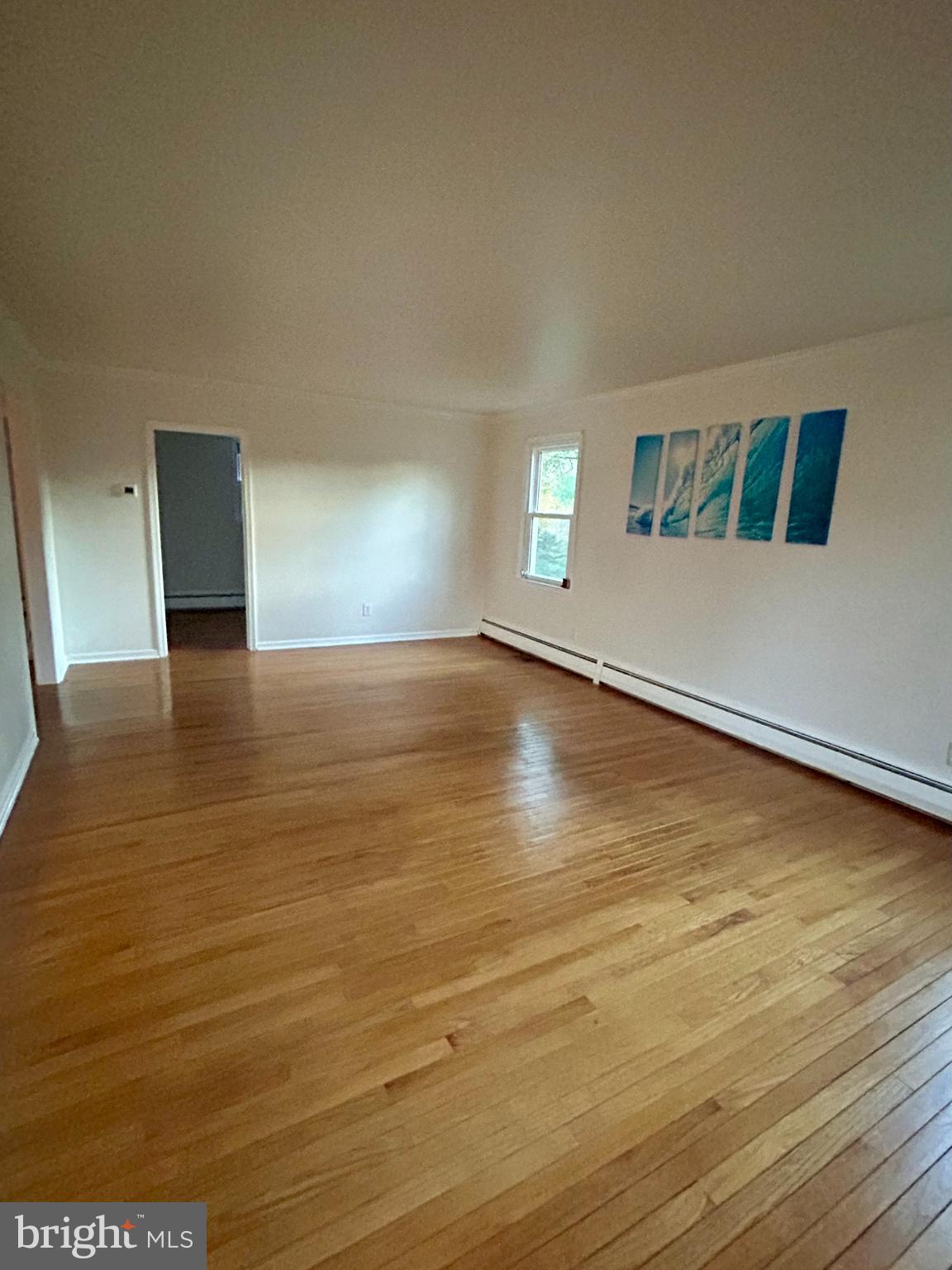 1007 Jones Road Conshohocken, PA 19428 - Photo 5 of 26 a view of an empty room with window and wooden floor