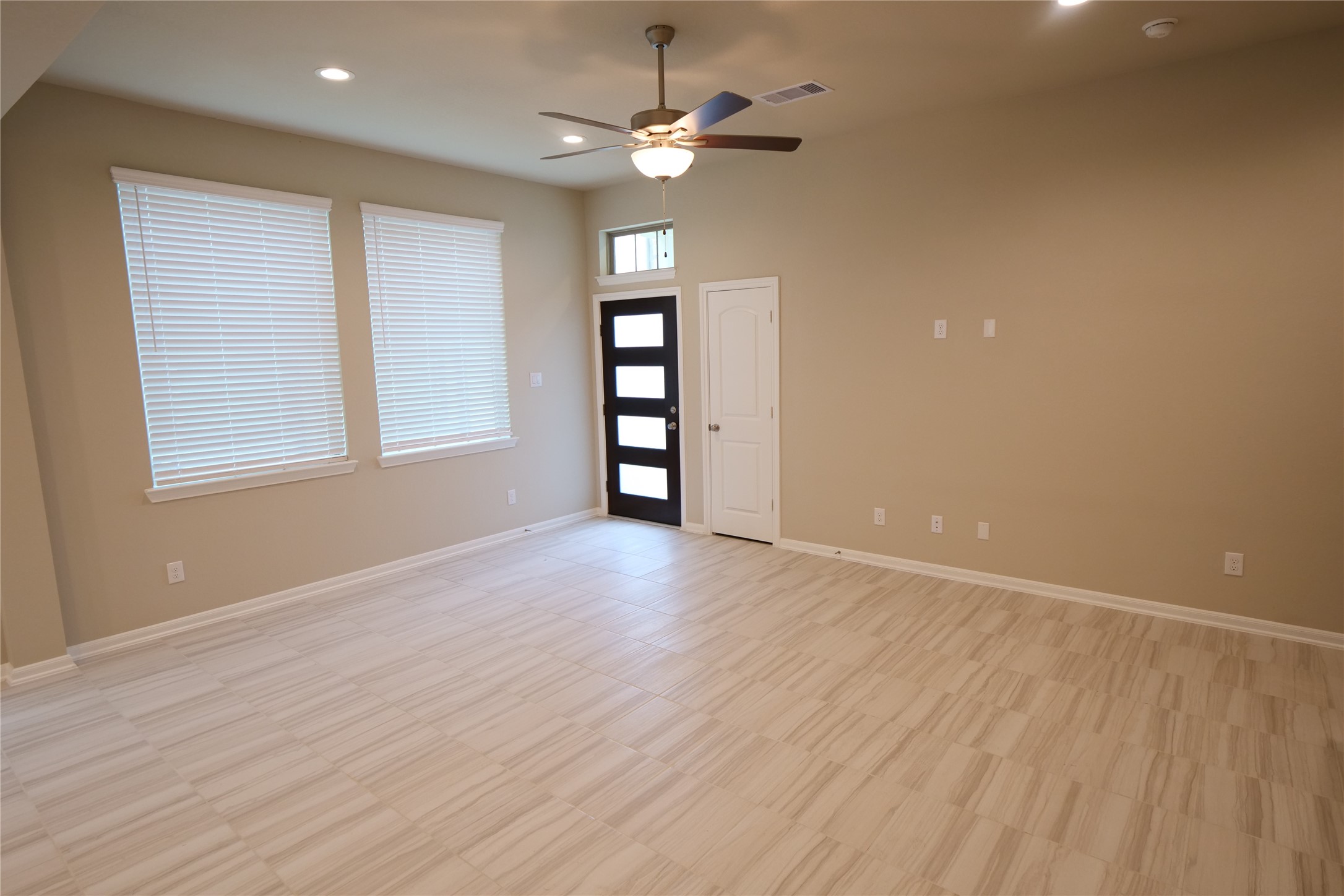 5110 Prairie Terrace Fulshear, TX 77441 - Photo 5 of 31 an empty room with wooden floor chandelier fan and windows