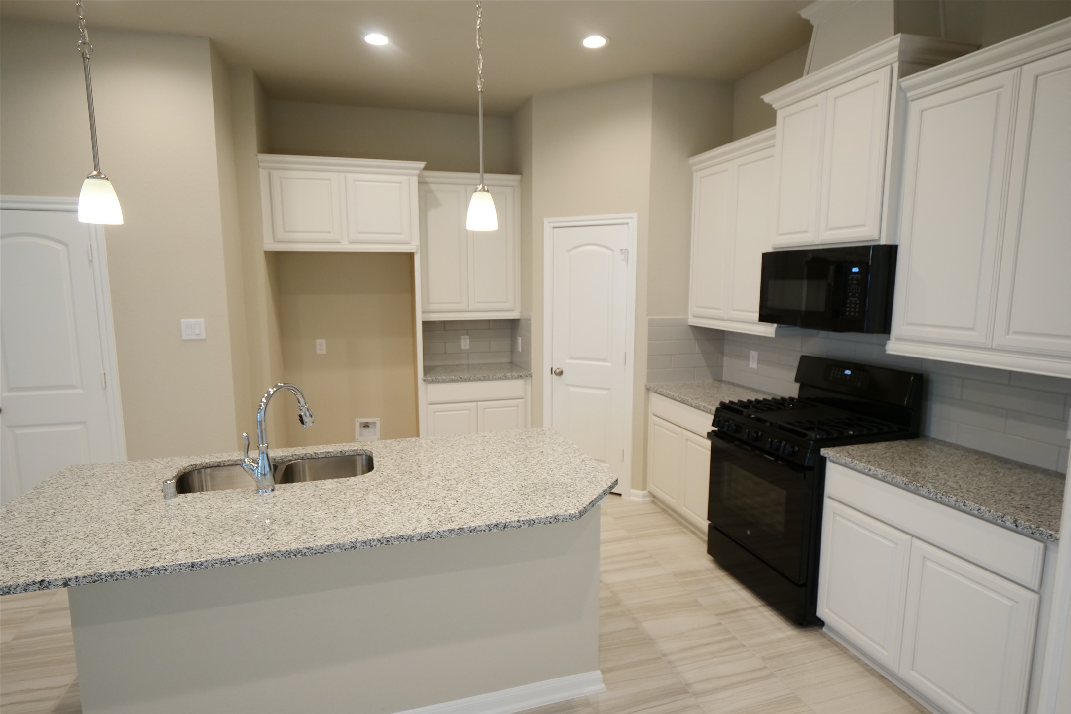 5110 Prairie Terrace Fulshear, TX 77441 - Photo 9 of 31 a large kitchen with granite countertop a sink and a stove top oven with wooden floor