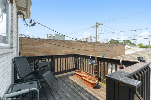 a balcony with wooden floor table and chairs