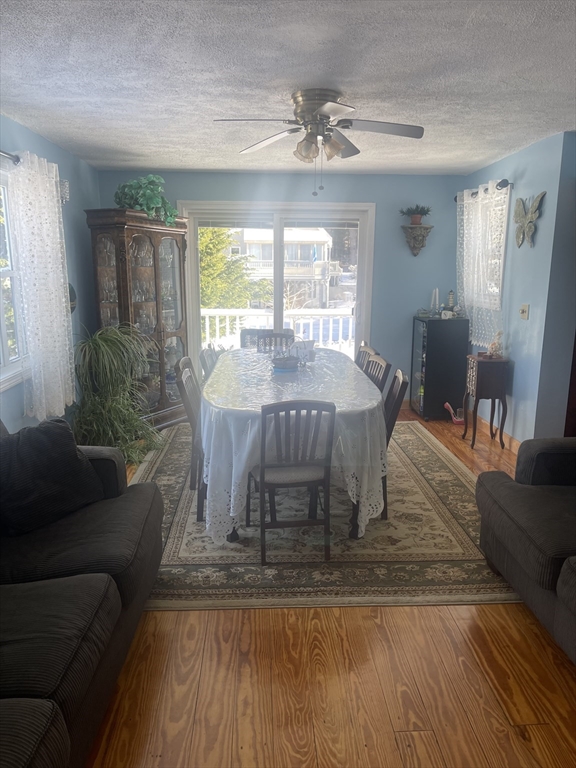 8 Scraggy Neck Rd Extension Bourne, MA 02534 - Photo 16 of 17 a dining room with wooden floor a chandelier a glass table and chairs