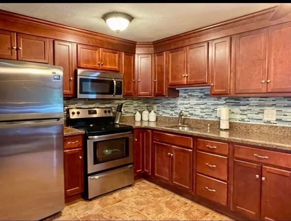 a kitchen with stainless steel appliances granite countertop a stove microwave and sink