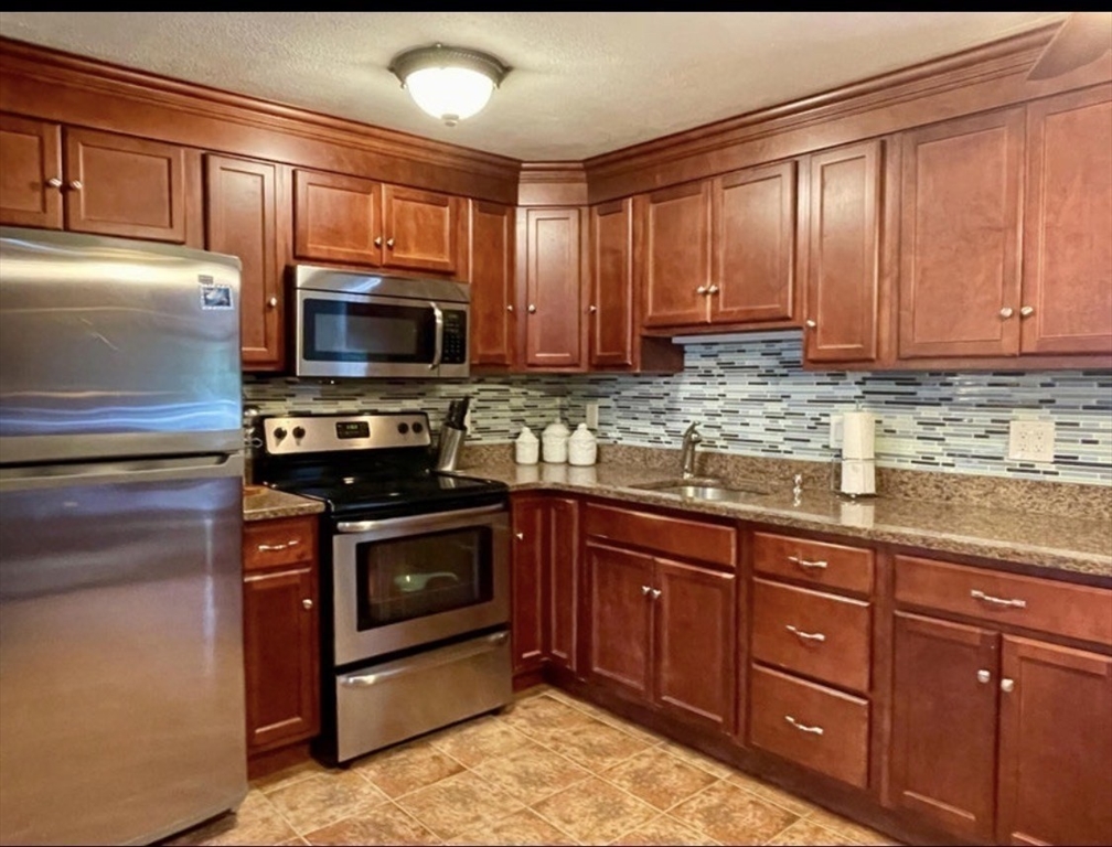 8 Scraggy Neck Rd Extension Bourne, MA 02534 - Photo 8 of 17 a kitchen with stainless steel appliances granite countertop a stove microwave and sink