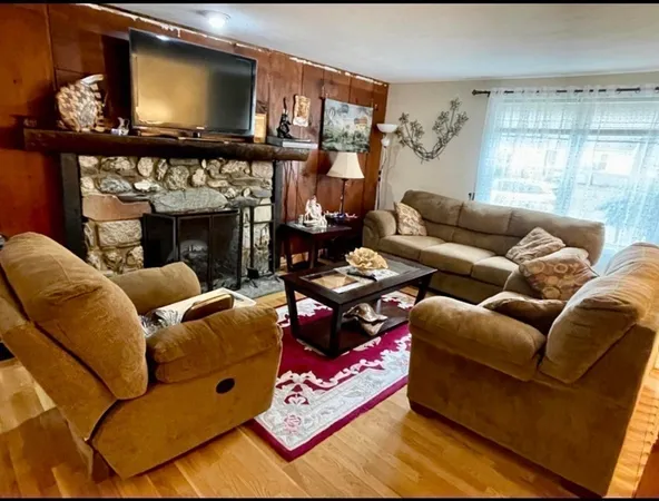 a living room with furniture a flat screen tv and a fireplace