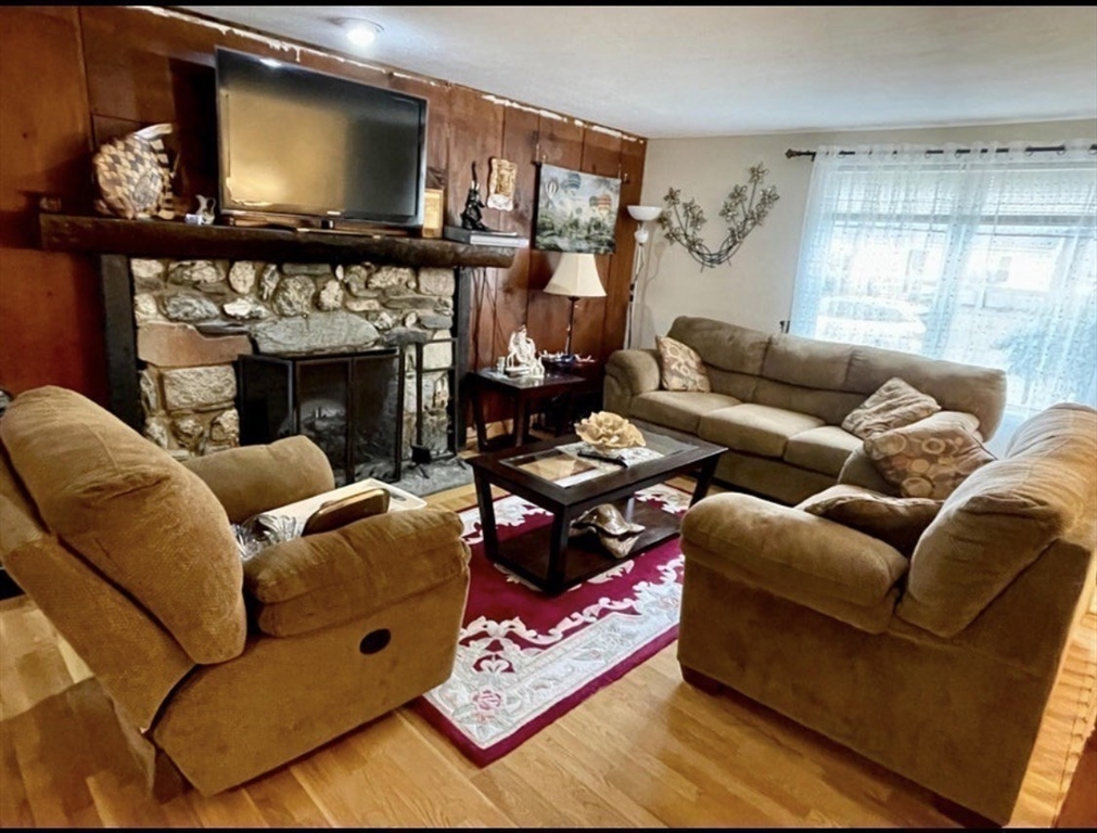 8 Scraggy Neck Rd Extension Bourne, MA 02534 - Photo 10 of 17 a living room with furniture a flat screen tv and a fireplace
