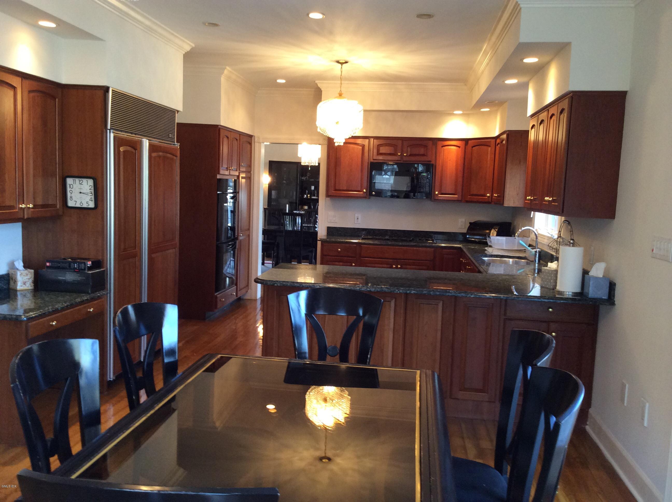3 Stanwich Road Greenwich, CT 06830 - Photo 4 of 17 a kitchen with stainless steel appliances granite countertop a refrigerator a stove and a sink with wooden cabinets