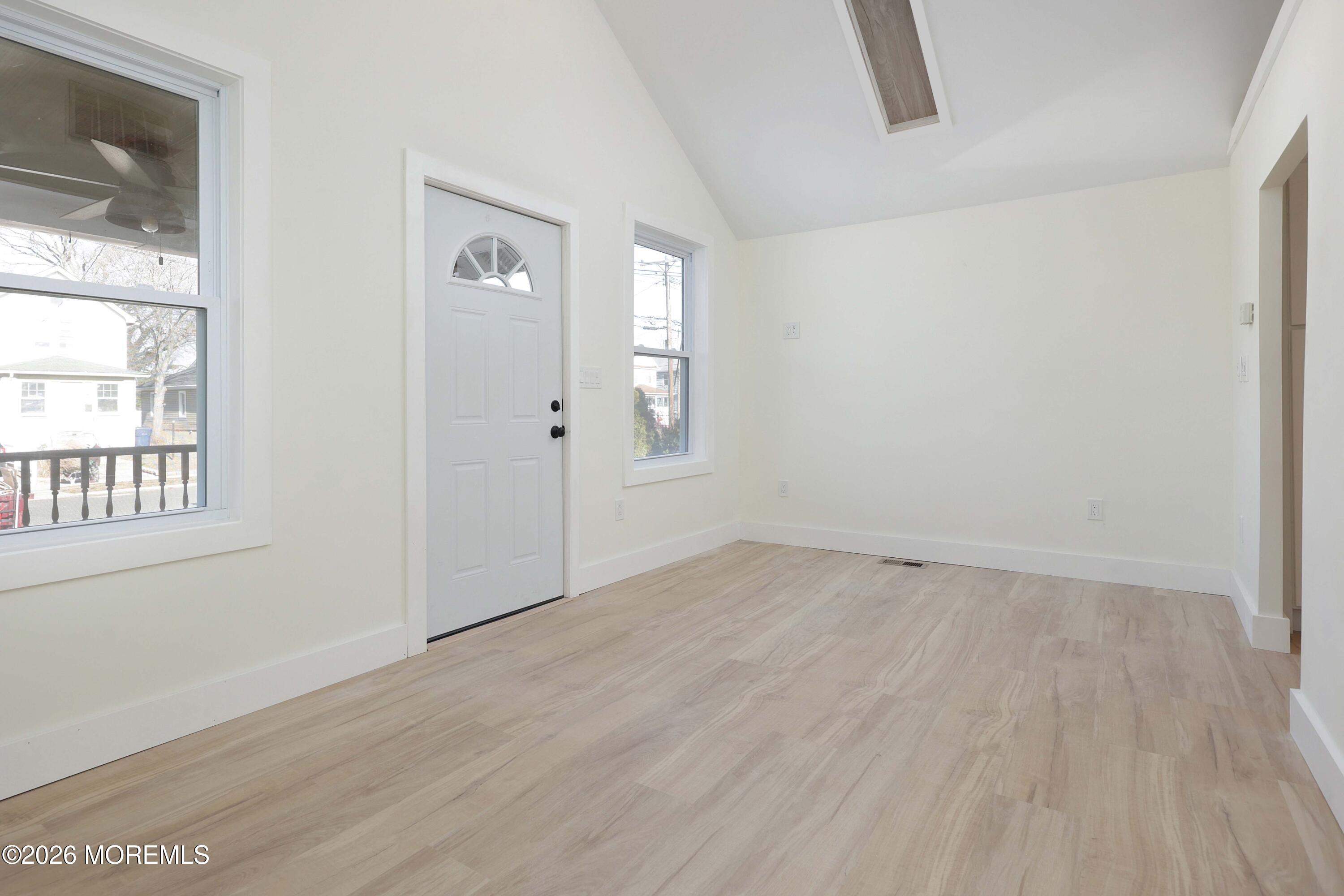 1216 8th Avenue Neptune, NJ 07753 - Photo 14 of 29 an empty room with wooden floor and windows