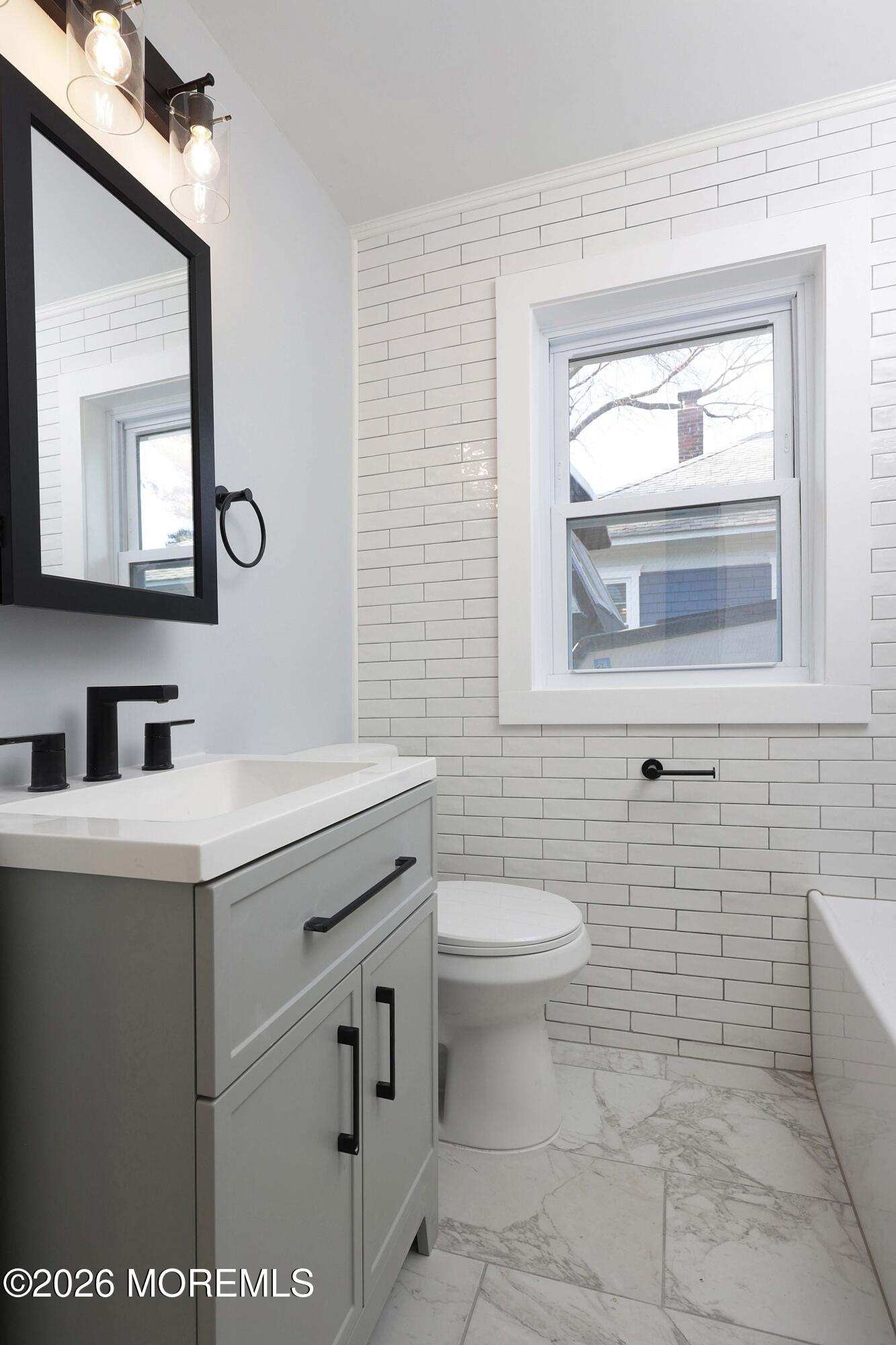 1216 8th Avenue Neptune, NJ 07753 - Photo 17 of 29 a bathroom with a sink a toilet and mirror