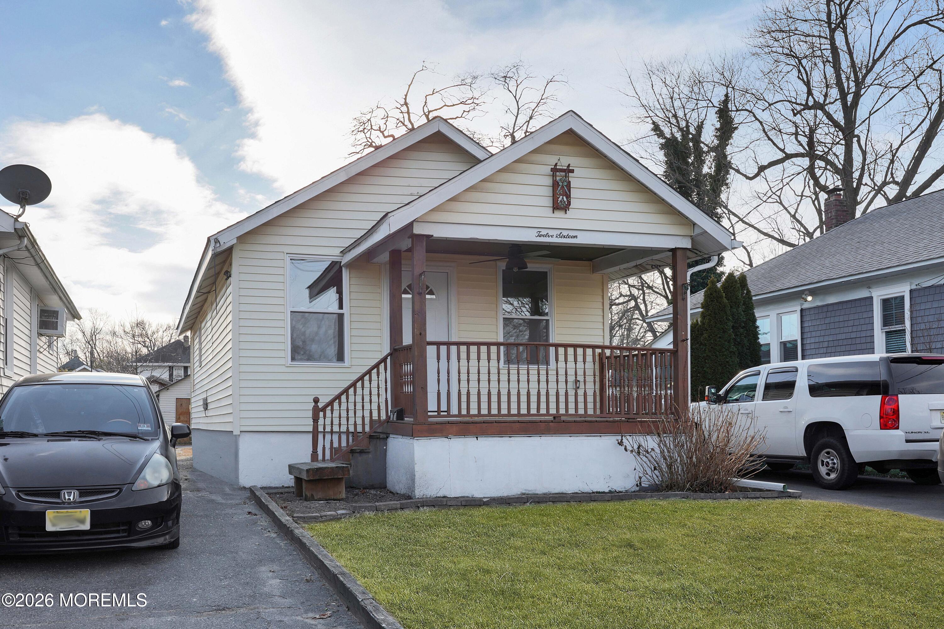 1216 8th Avenue Neptune, NJ 07753 - Photo 2 of 29 a front view of a house with a garden and parking space
