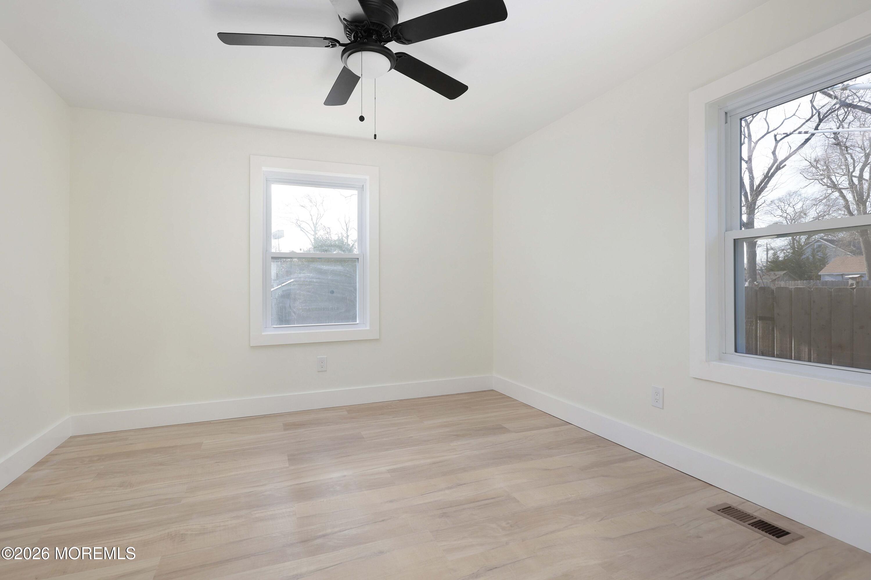1216 8th Avenue Neptune, NJ 07753 - Photo 21 of 29 an empty room with wooden floor fan and windows