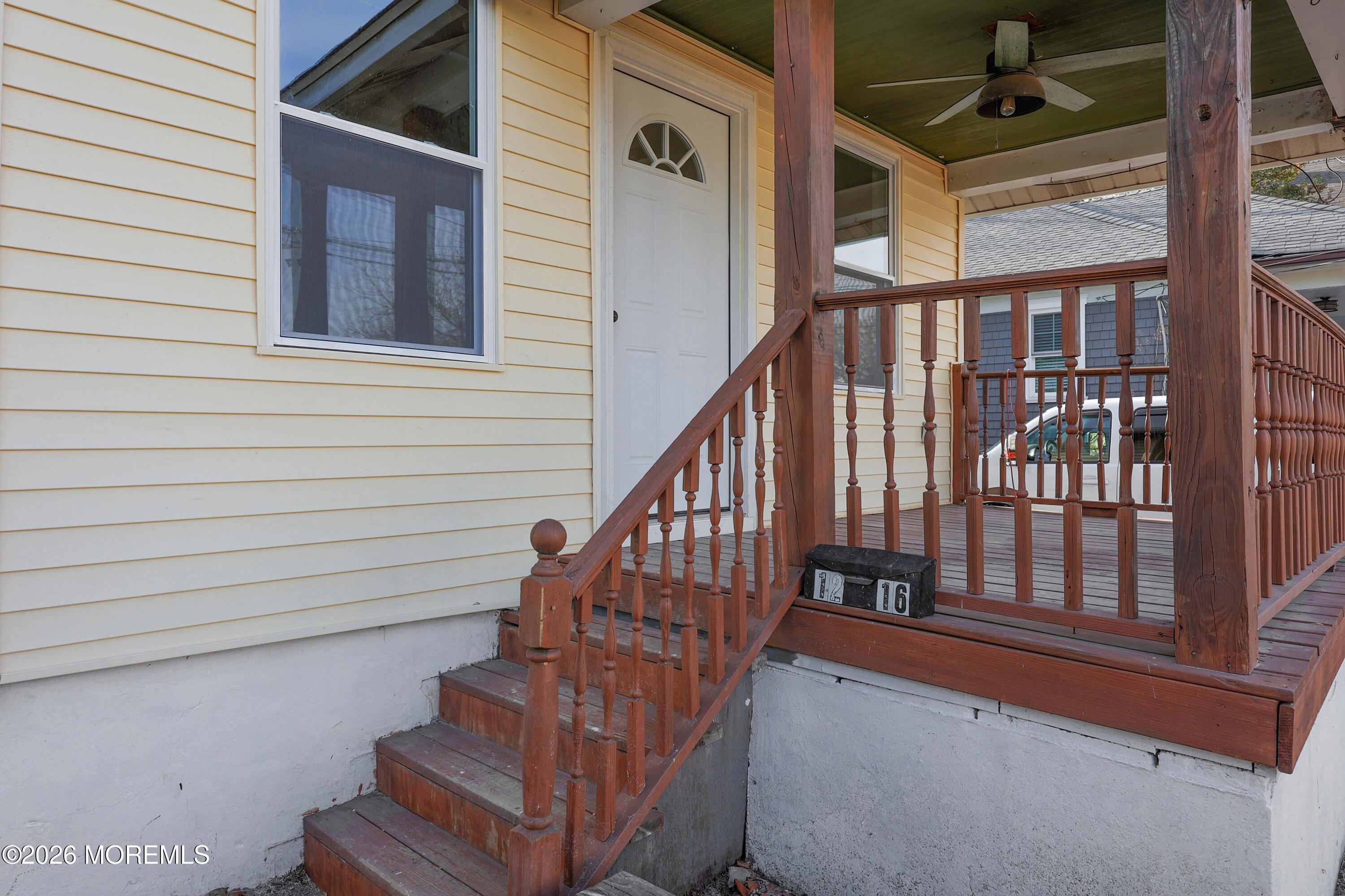 1216 8th Avenue Neptune, NJ 07753 - Photo 6 of 29 a view of staircase with lots of frames on wall and a potted plant