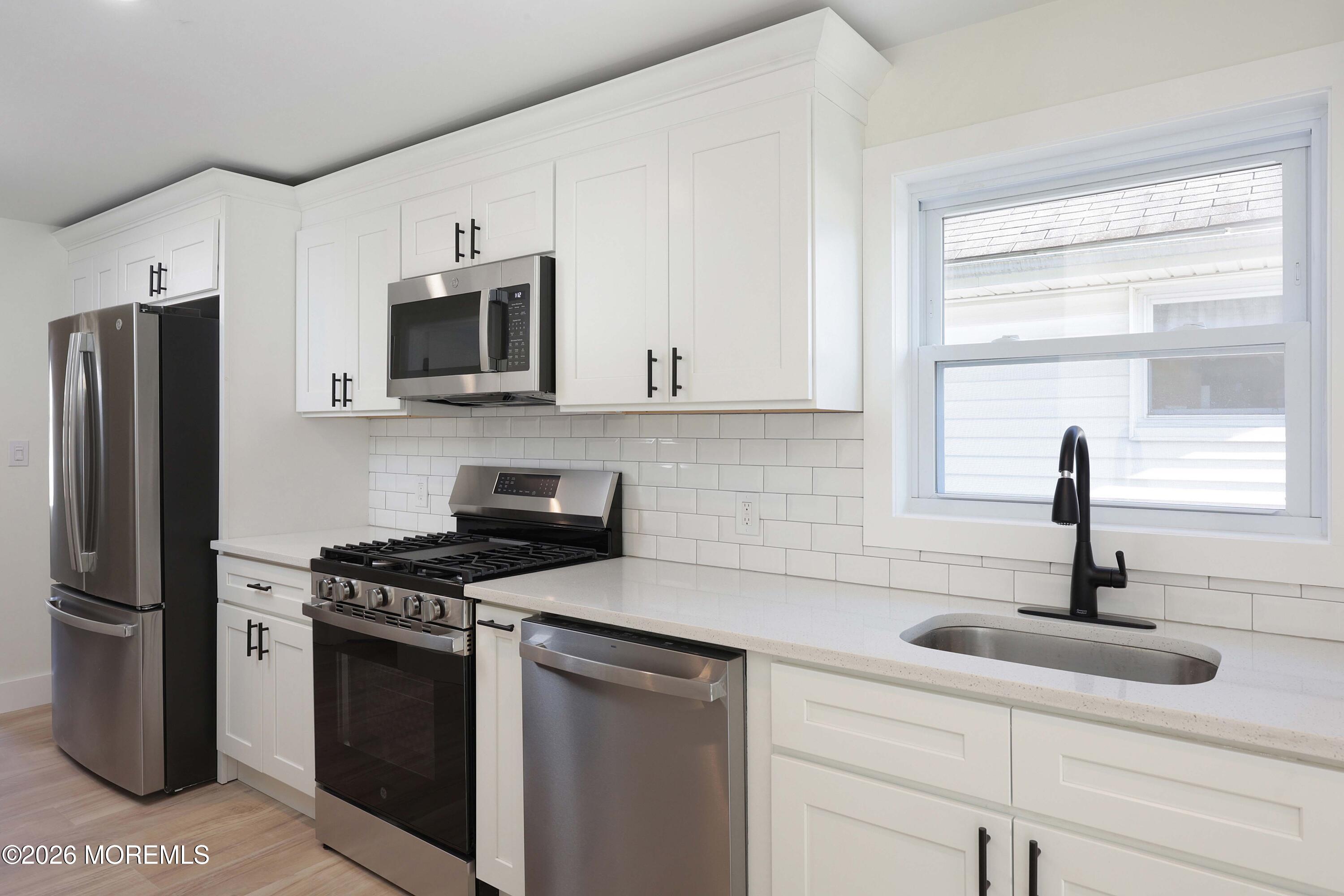 1216 8th Avenue Neptune, NJ 07753 - Photo 9 of 29 a kitchen with stainless steel appliances granite countertop a sink and a refrigerator