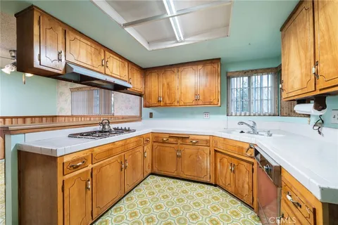 a kitchen with stainless steel appliances granite countertop a sink stove cabinets and wooden floor