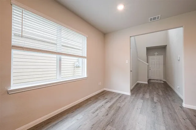 a kitchen with stainless steel appliances granite countertop a refrigerator a stove top oven a sink dishwasher and white cabinets with wooden floor