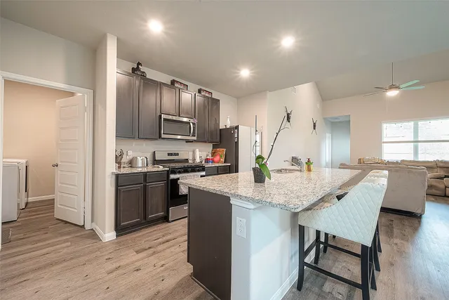 a kitchen with stainless steel appliances granite countertop a sink stove and wooden floor