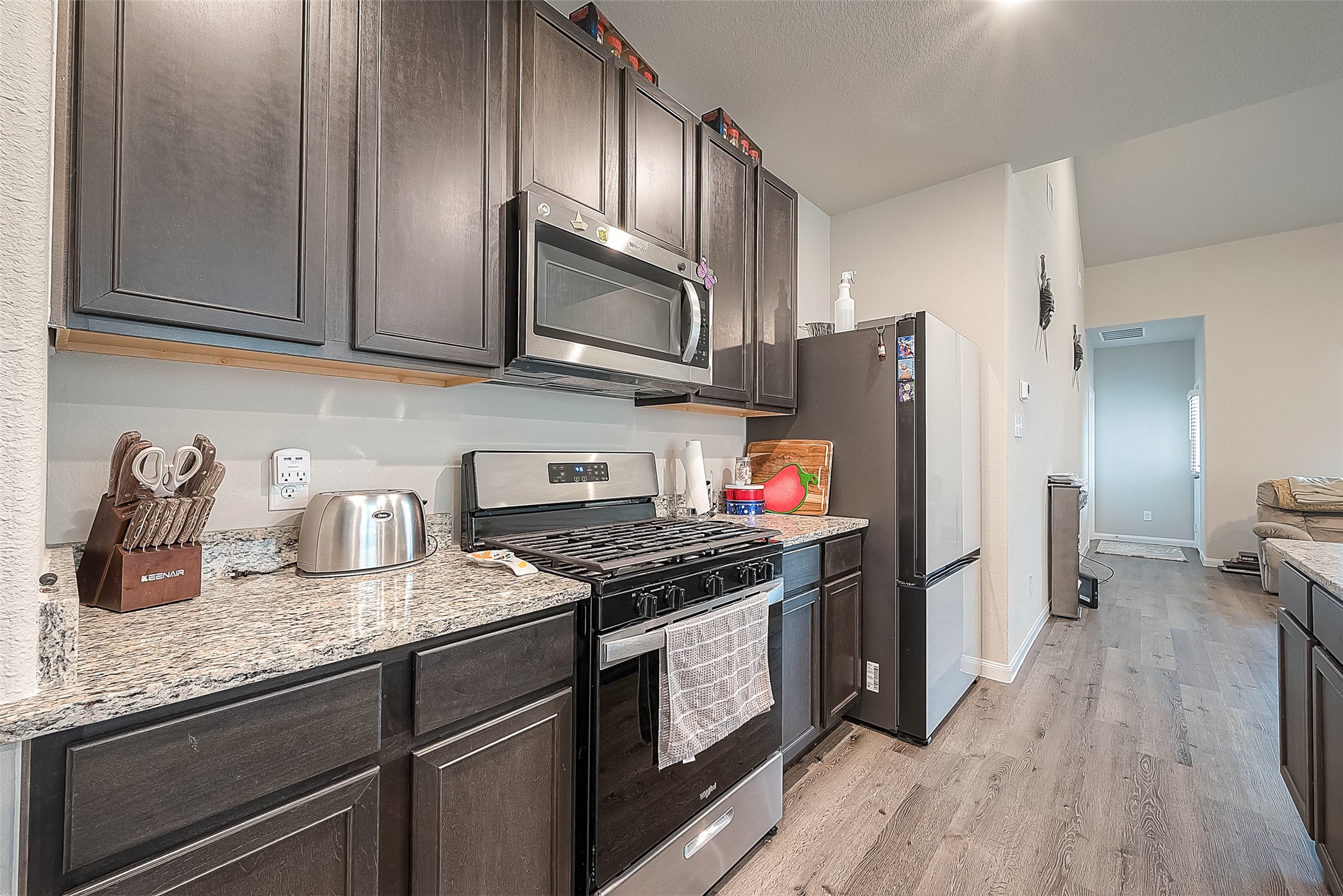1317 Mount Bassie Trail Conroe, TX 77301 - Photo 15 of 50 a kitchen with granite countertop a refrigerator stove and sink