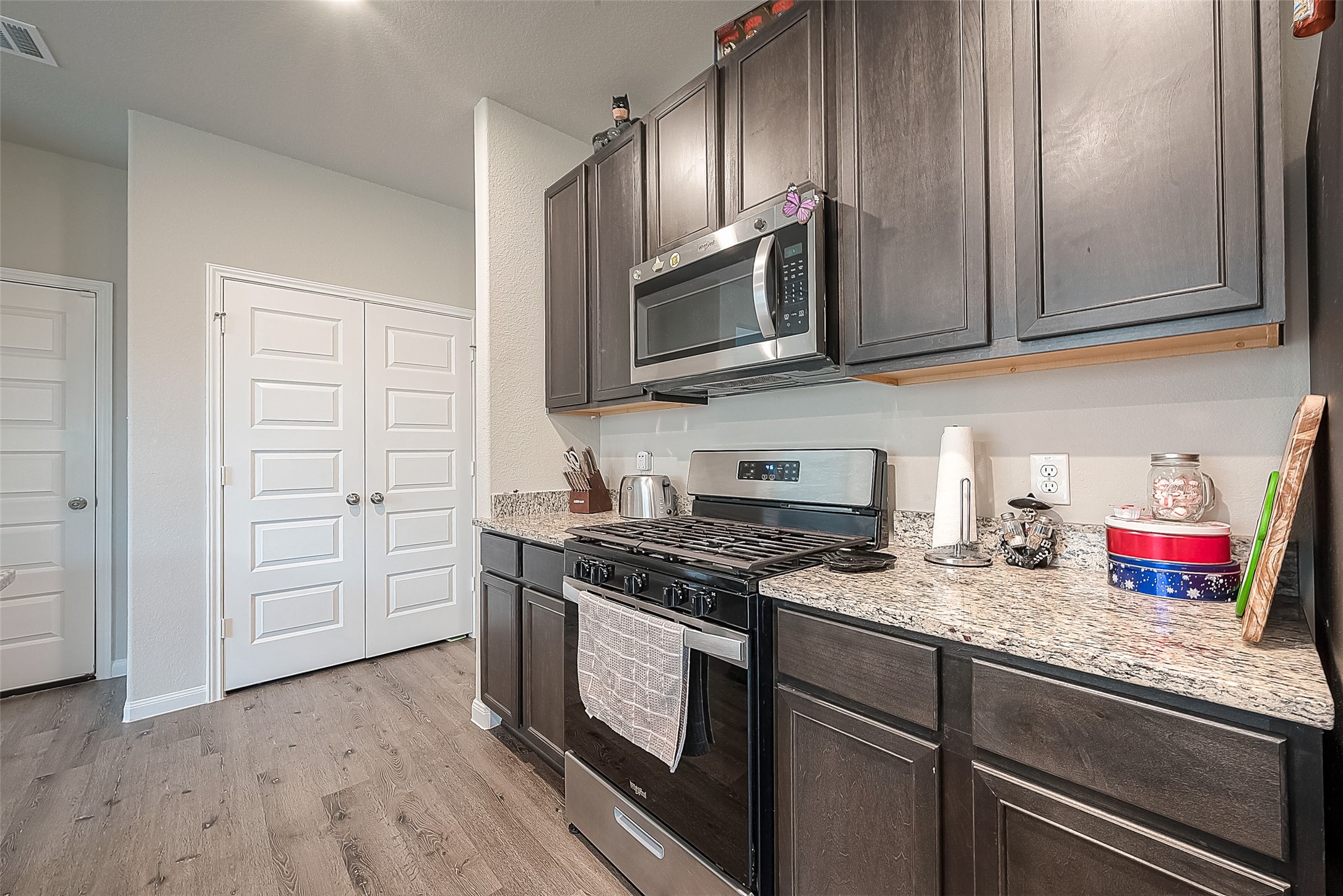 1317 Mount Bassie Trail Conroe, TX 77301 - Photo 19 of 50 a kitchen with stainless steel appliances granite countertop a stove and a microwave