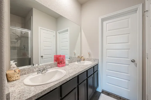 a en suite bathroom with a granite countertop sink and a mirror