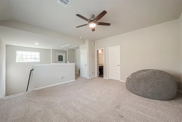 an empty room with fan and windows