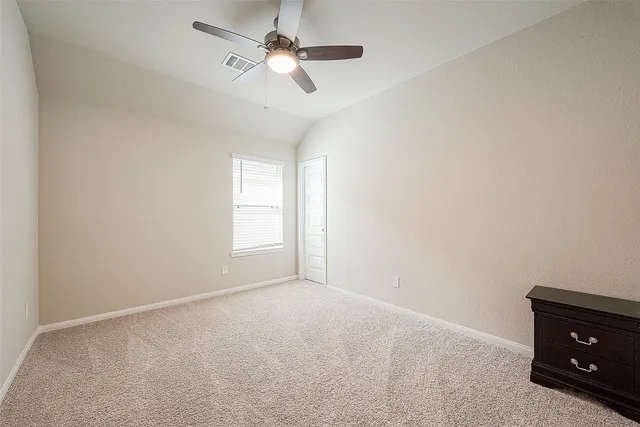 an empty room with a window and a ceiling fan