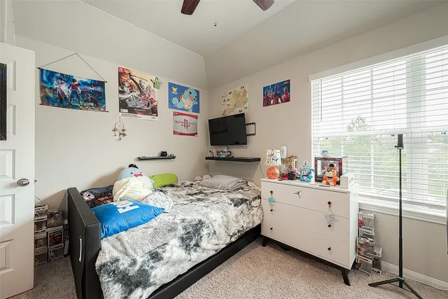 an empty room with ceiling fan and window
